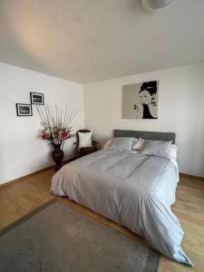 a bedroom with a large bed and a vase of flowers at Schweiz (302) in Basel