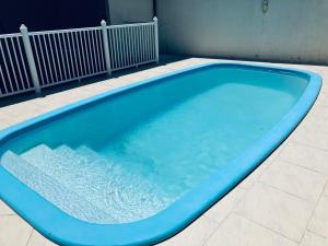 uma grande piscina azul num edifício em Townhouse composta por 4 triplex duas suítes a duas quadras do mar em Barra de Ibiraquera