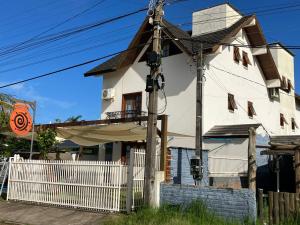 ein weißes Haus mit einem weißen Zaun in der Unterkunft Townhouse composta por 4 triplex duas suítes a duas quadras do mar in Barra de Ibiraquera