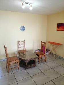 a living room with chairs and a table and a table at Kingswood Flats in Pretoria