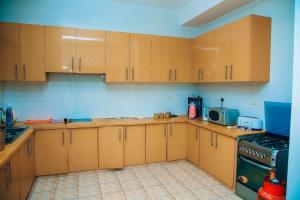 cocina con armarios de madera y fogones en Saint Emmanuel near Kigali Convetion center, en Bugesera