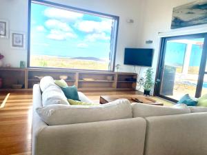 a living room with two white couches and a large window at Casa Estela in Villaverde