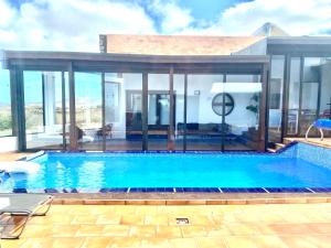 uma piscina numa casa com paredes de vidro em Casa Estela em Villaverde
