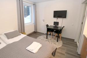 a bedroom with a bed and a desk with a computer at Kuukkeli Apartments Inari in Inari
