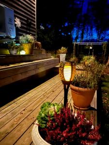 een lamp op een terras met bloemen en planten bij 15 min från Ullared! Ny stuga med hög standard! in Älvsered