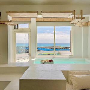 una camera da letto con una grande finestra con vista sull'oceano di White&Light B&B a Manzhou