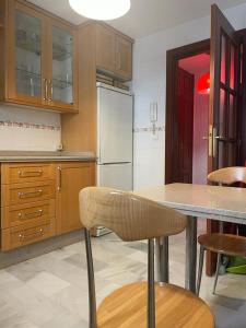 a kitchen with a table and a refrigerator at Duplex con garaje privado in Cádiz