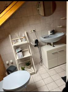 uma casa de banho com um lavatório e um WC em M & B Home em Nurembergue