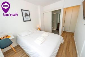 1 dormitorio con 1 cama blanca y 1 silla azul en Loc'Nuit - Chambres Tout Confort - Hyper Centre AGEN en Agen