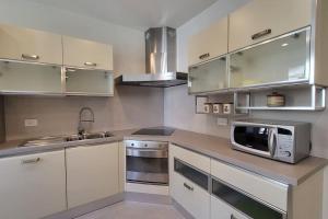 eine Küche mit weißen Schränken und einer Mikrowelle in der Unterkunft Appartamento Centro storico - Massa in Massa