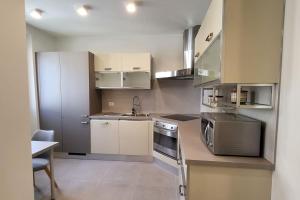 eine kleine Küche mit einer Spüle und einer Mikrowelle in der Unterkunft Appartamento Centro storico - Massa in Massa