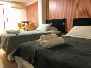 a hotel room with two beds with towels on them at Urbanature Filme e Arte BC in Balneário Camboriú
