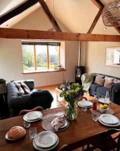 a living room with a wooden table with plates on it at Romantic Snowdonia Cottage with Hot tub, sea & mountain views in Tywyn