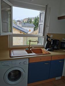 Una cocina con fregadero y lavadora y una ventana. en Foun Vive, en Font-Romeu