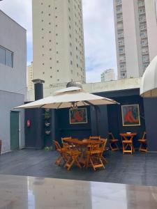 a patio with a table and chairs and an umbrella at Urbanature Filme e Arte BC in Balneário Camboriú