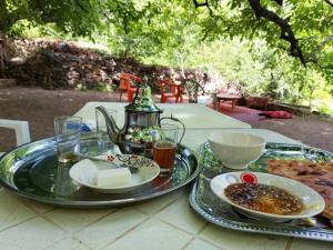 a table with two plates of food and a tea kettle at Auberge chez hammadi in Zagora