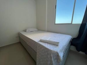 ein kleines Schlafzimmer mit einem Bett mit zwei Handtüchern darauf in der Unterkunft Apartamento de 3 habitaciones muy cerca al malecón in Barranquilla