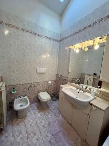 a bathroom with a sink and a toilet and a mirror at Vacanze Versilia in Viareggio