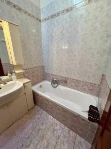ein Badezimmer mit einer Badewanne und einem Waschbecken in der Unterkunft Vacanze Versilia in Viareggio