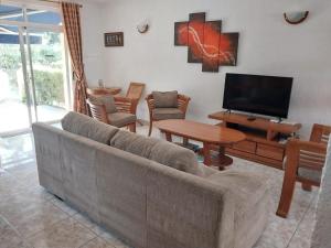 a living room with a couch and a flat screen tv at Le Tamier - Amazing holidays in Flic-en-Flac