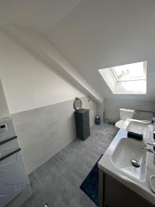 a white bathroom with a sink and a skylight at Jolie maison style champenois Classement 3 étoiles Gîtes de France in Barberey-Saint-Sulpice