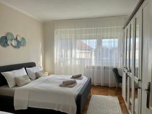 a bedroom with a large bed and a window at Apartman Cvjetnjak in Čakovec