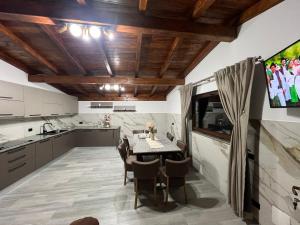 uma cozinha com mesa e cadeiras e uma televisão em Vila Mery em Moisei
