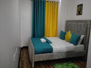 a small bedroom with a bed with colorful curtains at Two Bedrooms Furnished Apartment in Nakuru in Nakuru