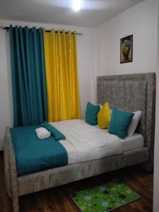 1 cama con cortinas coloridas en una habitación en Two Bedrooms Furnished Apartment in Nakuru en Nakuru