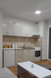 a kitchen with white cabinets and a stove top oven at Apartman Pale - Biljana in Pale
