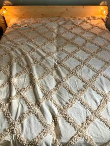 um close-up de uma cama com um cobertor sobre ela em Haus am Lübbesee em Templin