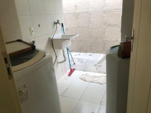 een badkamer met een wastafel en een wasmachine bij Casa térrea em Guarajuba para Veraneio in Camassari