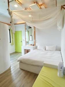 una camera con un letto bianco e una porta verde di White&Light B&B a Manzhou