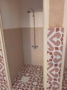 a shower in a bathroom with a tile floor at شاليه ندى in Buraydah