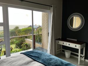 a bedroom with a bed and a mirror and a window at Bloudam Wilderness in Wilderness