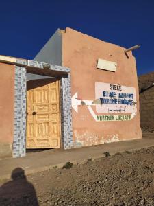 ein Gebäude mit einer Holztür in der Wüste in der Unterkunft Dar Dyafa 