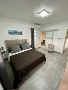 a bedroom with a large bed and a chair at LES VILLAS PAMEYAQUE 2 F2 avec 1 piscine et 1 F3 avec 1 piscine, Superbe Vue sur la mer in Rivière-Salée