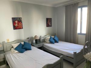 - une chambre avec 2 lits dotés d'oreillers bleus dans l'établissement Ras Katy Sunset Views, à Charm el-Cheikh