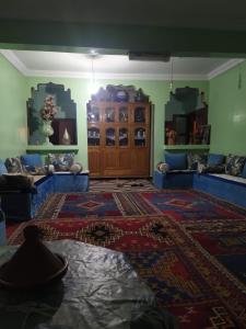 a living room with blue couches and a rug at Dar Dyafa 