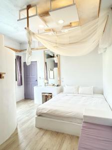 滿州鄉的住宿－白色領地日出海景民宿，卧室配有白色床和天花板