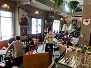 a group of people sitting at tables in a restaurant at Labkoff cafe and Hostel in Kanchanaburi City