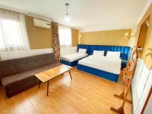 um quarto de hotel com uma cama e um sofá em Hotel Orange Kutaisi em Kutaisi