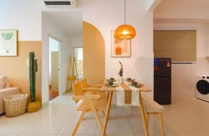 a living room with a table and chairs and a kitchen at Greenfield Residence At Sunway City by Nexx Field in Petaling Jaya
