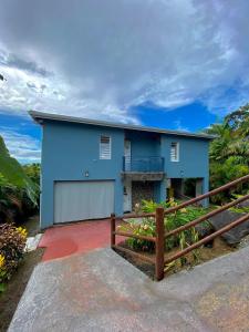 a blue house with a fence in front of it at LES VILLAS PAMEYAQUE 2 F2 avec 1 piscine, 1 F3 avec 1 piscine privée, Superbe Vue Mer in Rivière-Salée