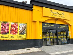 een gele winkel met borden aan de zijkant bij Spacious, comfortable and close to the beach in Torre del Mar