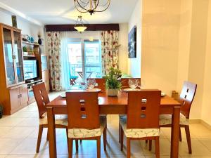een eetkamer met een houten tafel en stoelen bij Spacious, comfortable and close to the beach in Torre del Mar