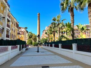 een straat met palmbomen en een paal op een stoep bij Spacious, comfortable and close to the beach in Torre del Mar