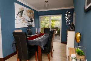 a dining room with blue walls and a table and chairs at Harmony Haven Executive Suite in Nottingham