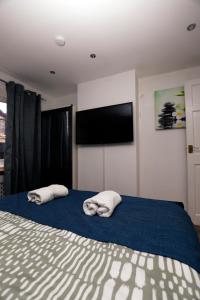 two towels on a bed with a flat screen tv at Harmony Haven Executive Suite in Nottingham