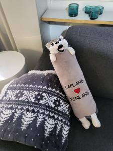 a stuffed animal sitting on a bed with a blanket at Cozy studio in the city center in Rovaniemi